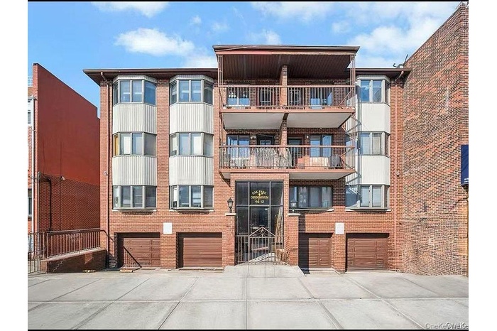 View of apartment building / complex with driveway and a garage