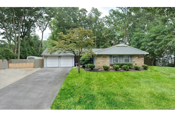 Single story home featuring stone siding and a garage