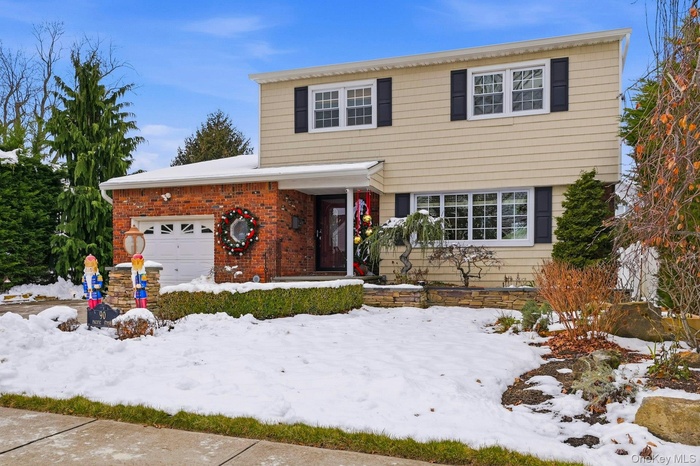View of front of home with an attached garage and brick siding