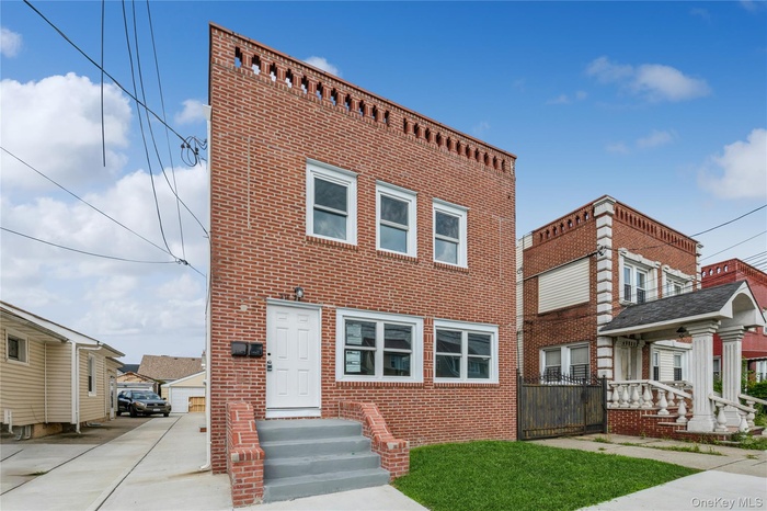 View of front of property with brick siding and a front yard