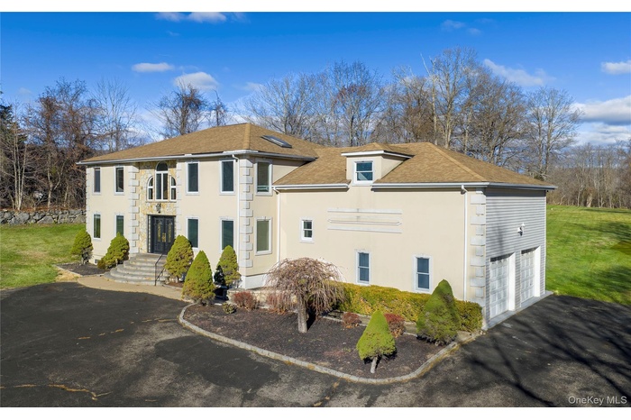 Nestled at the end of a peaceful cul-de-sac on 1.78 acres of lush, parklike grounds with an inground pool.