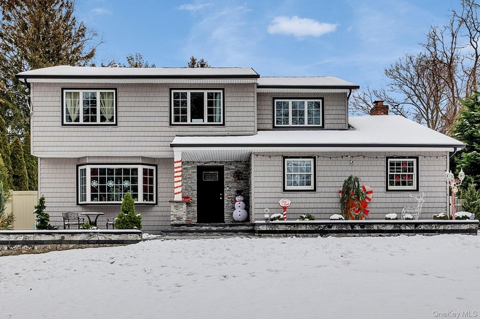 View of front of home featuring a chimney and a porch