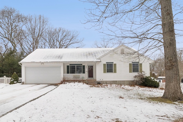 View of front of house featuring a garage and covered porch