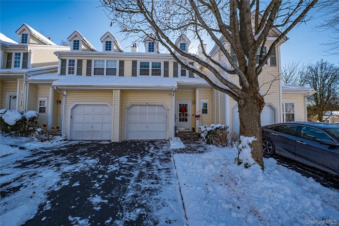 Traditional-style house featuring an attached garage and driveway