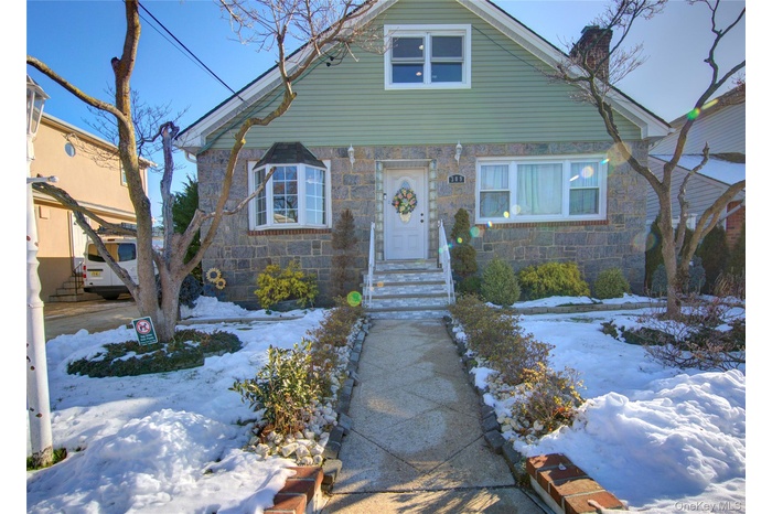 Bungalow-style house featuring stone siding and a chimney