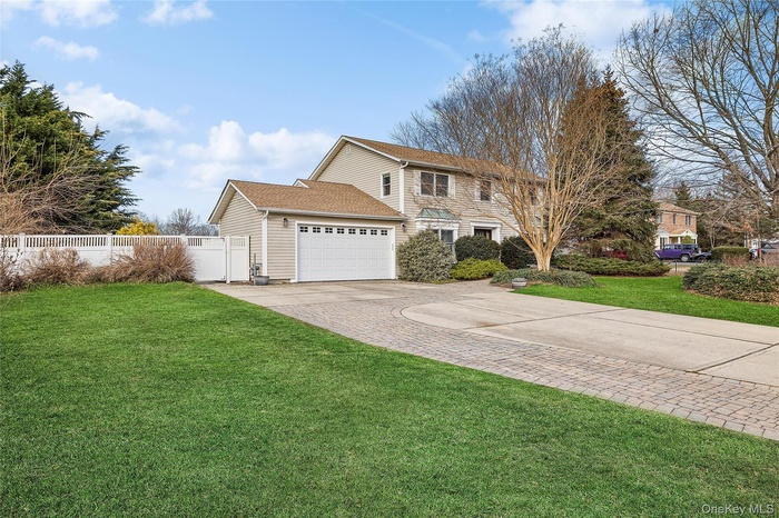 View of front of house featuring concrete driveway, a garage, and roof with shingles