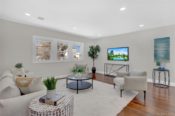 Living area with wood finished floors and recessed lighting