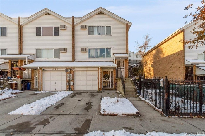 View of front of home featuring driveway, an attached garage, and stairs