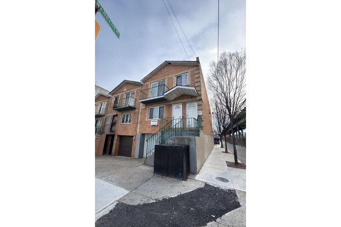View of front of house with brick siding, a balcony, an attached garage, and concrete driveway