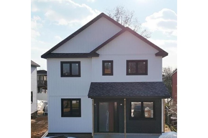 Back of property featuring a shingled roof