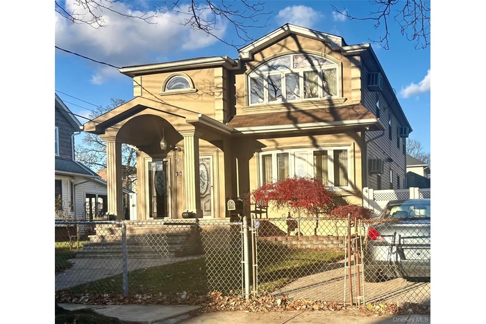 View of front of house featuring a fenced front yard, a gate, and a wall mounted AC