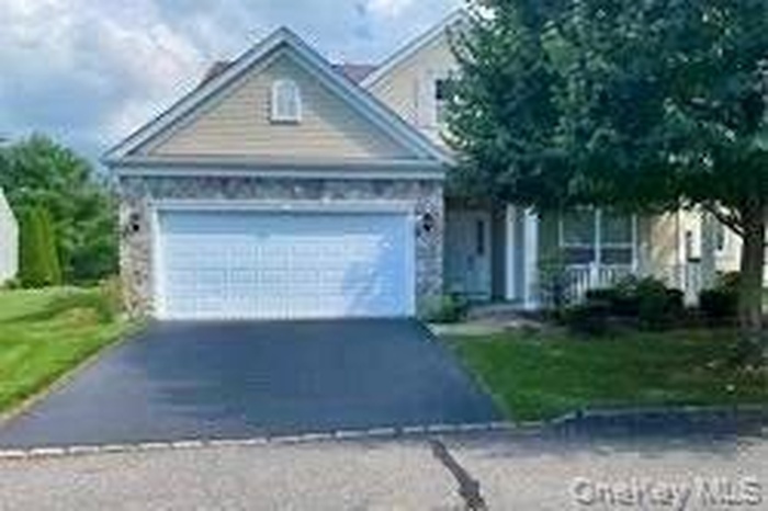 View of front of property featuring driveway and an attached garage