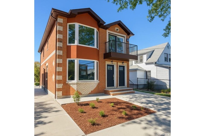 Contemporary house featuring a balcony and brick siding