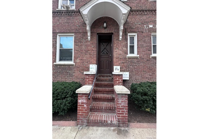 Doorway to property featuring brick siding