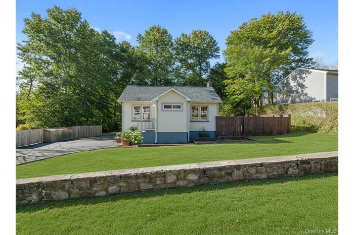 View of front facade featuring a chimney and roof with shingles