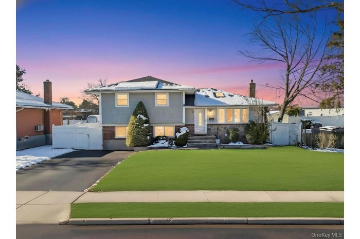 Split level home with a gate and driveway