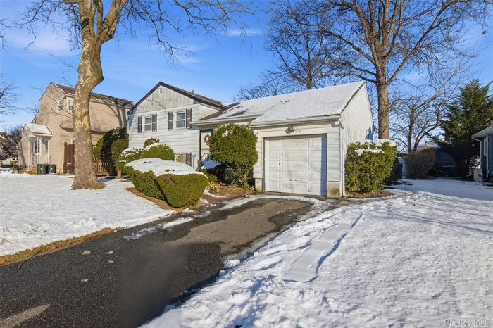 View of front of property with driveway and an attached garage