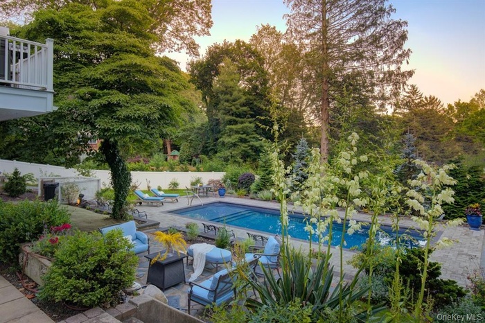 Pool at dusk featuring a patio and an outdoor hangout area
