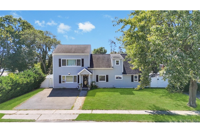 View of front facade with asphalt driveway and a shingled roof