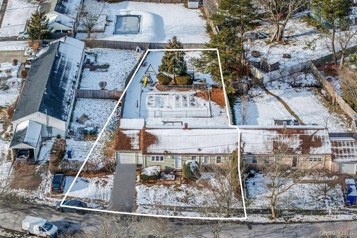 Snowy aerial view featuring property parcel outlined
