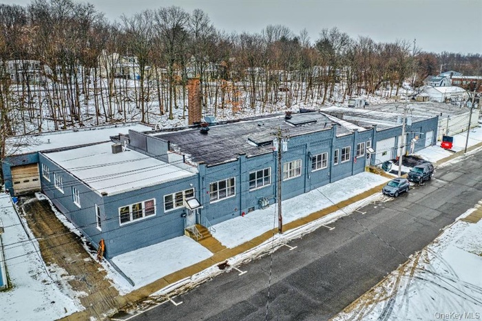 Snowy aerial view with view of wooded area