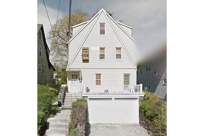 View of front of house featuring stairway, driveway, and an attached garage
