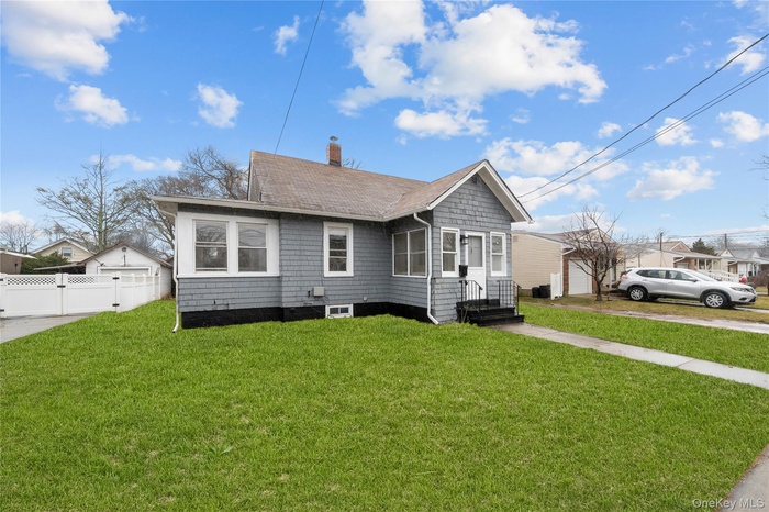 View of front of house with a chimney and roof with shingles
