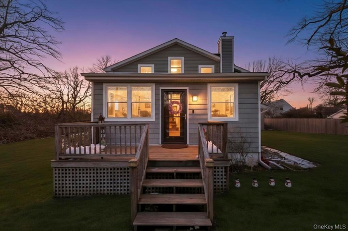 Back of house with a chimney and a wooden deck