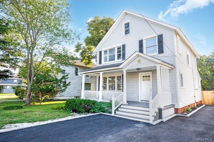 View of front of home with a porch and a front yard