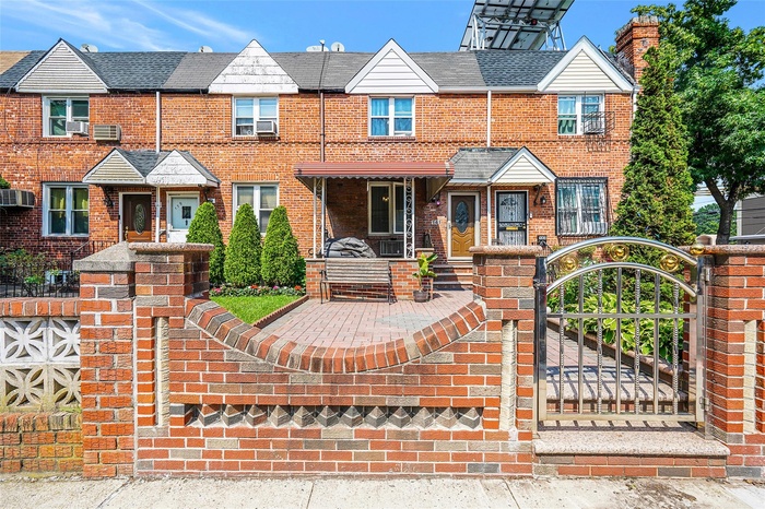 Townhome / multi-family property with brick siding and a gate