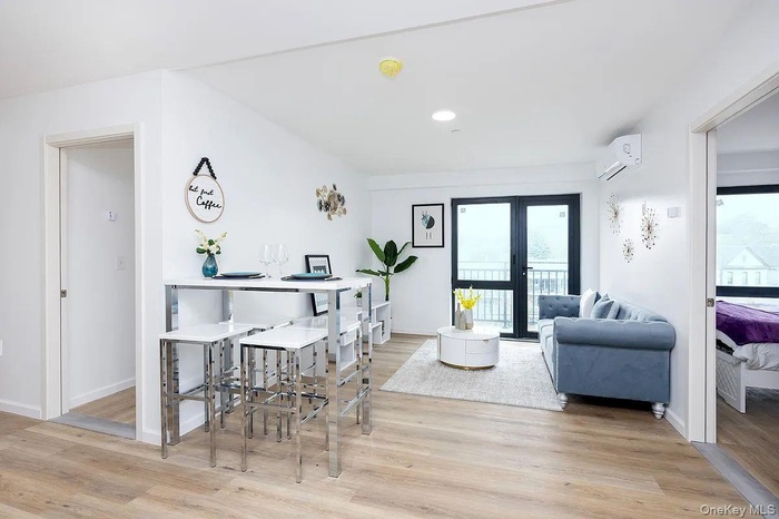 Dining room with plenty of natural light, an AC wall unit, light wood-type flooring, and recessed lighting