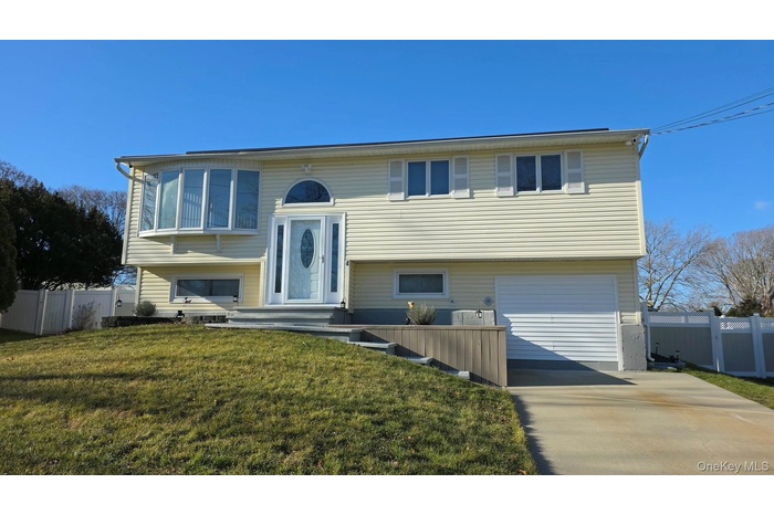 Split foyer home featuring an attached garage and driveway