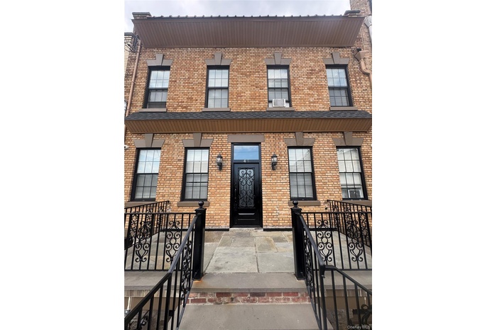 View of front of home with brick siding and cooling unit