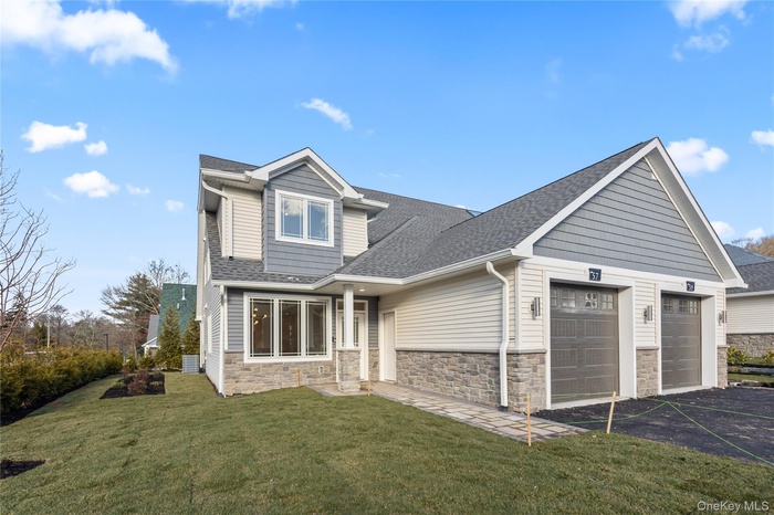 View of front facade with roof with shingles, stone siding, an attached garage, asphalt driveway, and a front lawn