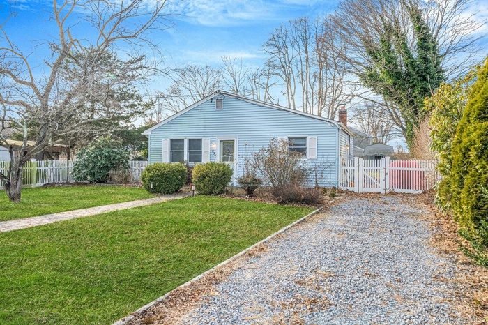 View of front of home with a chimney and a gate