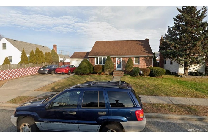 New england style home featuring brick siding and a front lawn