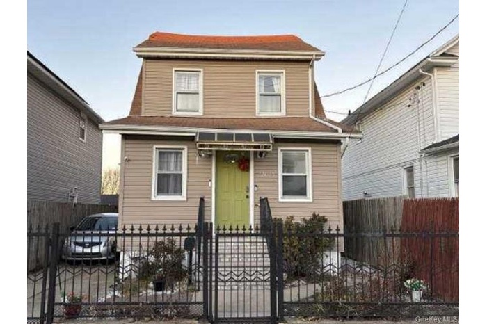 View of front of property featuring a fenced front yard and a gate
