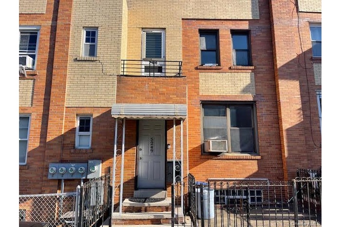 View of front of home with a fenced front yard, brick siding, a gate, and cooling unit