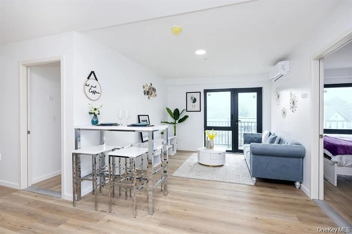 Dining room with plenty of natural light, a wall unit AC, light wood-style flooring, and recessed lighting