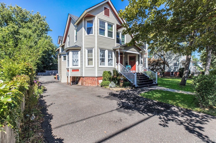 View of front facade with a front yard and driveway