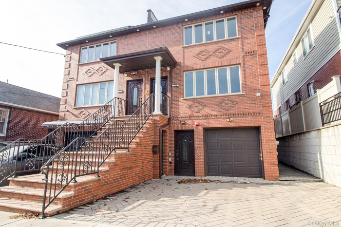 View of front of house with brick siding and an attached garage