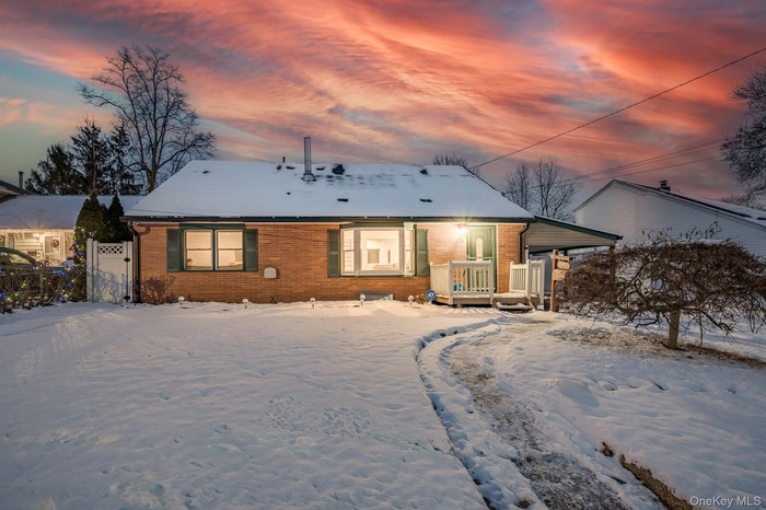 View of front of property featuring brick siding, a deck, and a gate