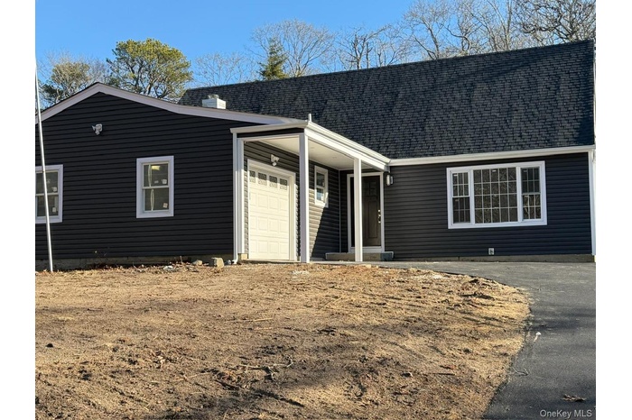 View of front of home featuring an attached garage and roof with shingles