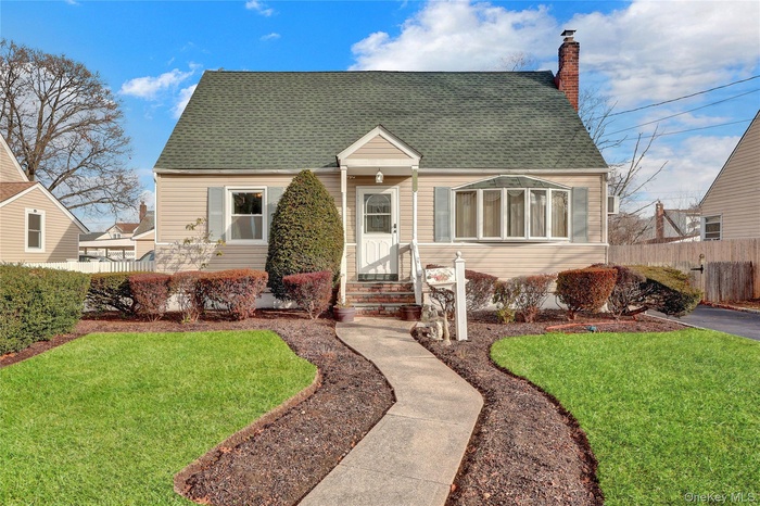 Cape cod home featuring roof with shingles and a chimney