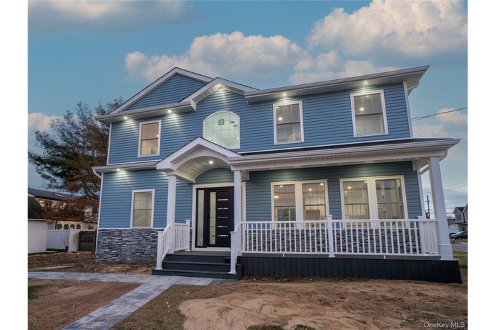 View of front of home with covered porch and stone siding