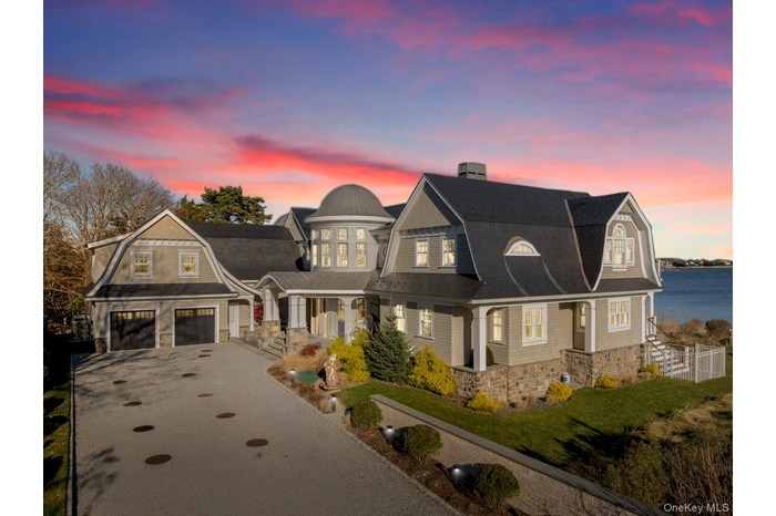 View of front of home featuring a gambrel roof, roof with shingles, and driveway