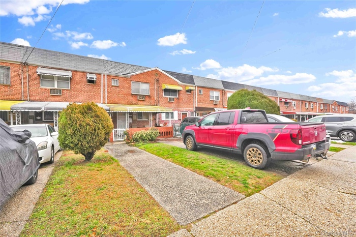 View of front of house with brick siding, a residential view, and roof with shingles