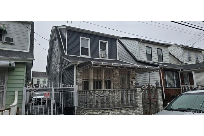 View of front of property with stone siding and a gate