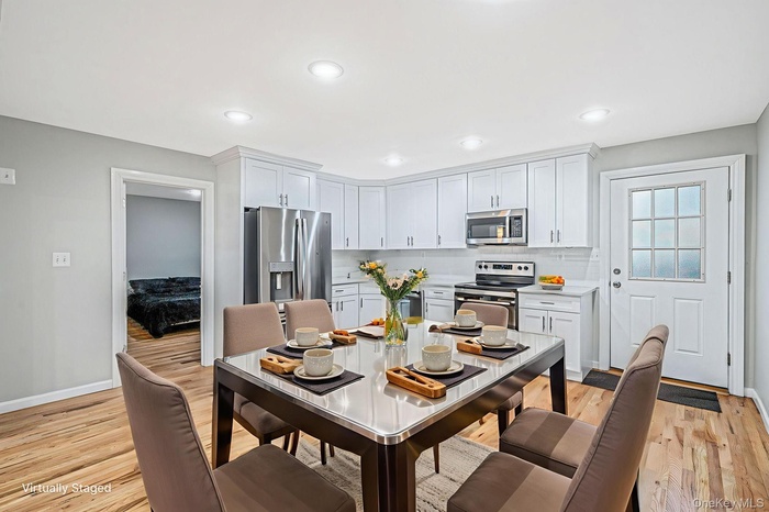 Kitchen featuring light countertops, stainless steel appliances, light wood-style flooring, tasteful backsplash, and recessed lighting