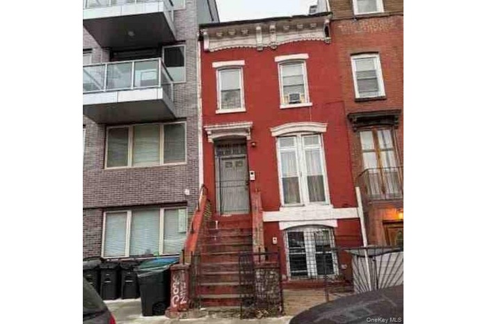 View of front facade with brick siding and a balcony